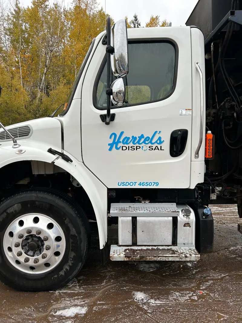 A freshly washed refuse truck cab in a customer's yard