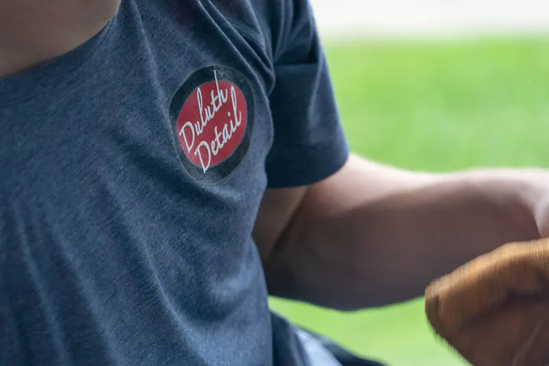 The Duluth Detail logo on a technician's shirt